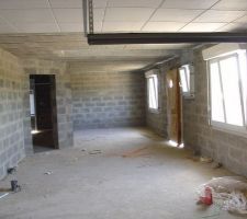 Salle de jeux au 1er plan, bureau dans le fond