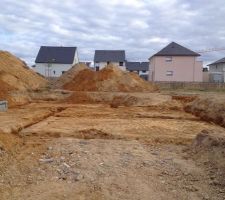 Le sol est creus&eacute; pr&ecirc;t &agrave; couler les fondations.
Deux tas de terre: la mauvaise a &eacute;vacuer et la bonne a garder pour la fin de chantier.