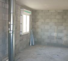 Avec le conduit de fumée du poêle à granulés et sur sa droite la chambre de ma fille et sur sa gauche celle de mon fils.
