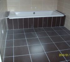 Salle de bain le carrelage est weng&eacute; au sol et sur la baignoire et au mur il est beige