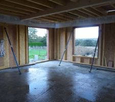 Salon avec une baie coulissante donnant sur la terrasse et une fenêtre fixe donnant sur le terrain