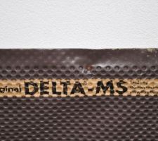 Pose du Delta-MS après avoir mis l'enduit bitumeux. Le Delta-MS ne sert qu'à protéger le mur à la remise des terres et en aucun cas à assurer l'étanchéité !