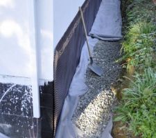 Une fois les cailloux finis d'être correctement répartis, on recouvre les cailloux avec le drain dans le géotextile.