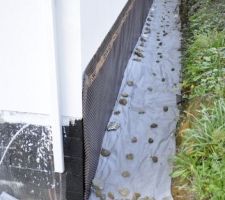 Pose du drain terminée : géotextile recouvert de grosses pierres pour pas qu'il s'envole avant la remise des terres.