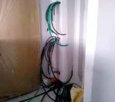 La tableau électrique en cours. Très bonne organisation des fils par l'électricien qui profite du caisson pour tout camoufler. En haut les prises TV et RJ45 (en attente de la box et du routeur), au milieu les disjoncteurs et en bas les réserves de gaine pour les futurs projets (piscine, aménagement du garage un de ces jours, peut-être...)