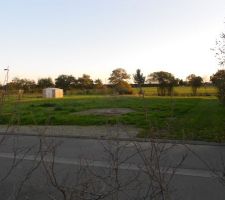 Vue du terrain.
L'entr&eacute;e par la route se situe plein nord.
Le paysage au fond constitue la vue plein sud.