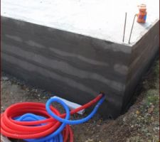 La dalle est coulée avant les températures négatives ...
Le tuyau pvc rouge permet de distribuer de l'électricité depuis le tableau électrique vers le côté nord du jardin.
Le tuyau bleu permettra de relier l'eau froide vers extérieur.
vue depuis le côté nord de la maison. Côté arrière-cuisine