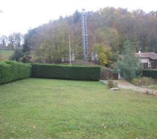 Vue sud, avec vue sur l'acces du terrain et on voit le d&eacute;but du chemin qui traverse tout le terrain et on voit la source(l'arbre touffu proche du chemin et devant il y a un "truc en beton"
