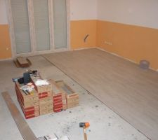 Après la peinture, c'est la pose du carrelage imitation parquet.