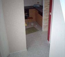 Descente d'escaliers avec vue sur la cuisine et l'entrée