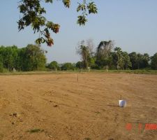 2009 - juillet reblai de 25 cm d'une terre avec caillou sur une zone de 2500m&sup2; ou sera construite la maison. sur la photo approximativement l&agrave; ou il y a le chaier et les piquets en fond.