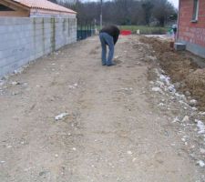 Accès chantier entre le mur des voisins et une maison en construction.