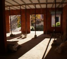 Vue du salon vers la salle à manger à droite et la cuisine à gauche