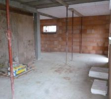 La cuisine en premier plan et garage apres le poteau