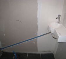 Avant tout, j'ai installé dans la cloison une arrivée d'eau et un tube PVC tout cela reliés à ceux des WC. Cela pour y installer un lave main.