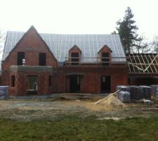 Vue de devant de la maison - couverture terminée pour la maison et en cours pour le garage. tuiles livrées