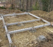 Après avoir placé les socles au cm prêt mise en place des poutres et scellement avec du béton.