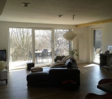 Le séjour. Au sol un carrelage effet parquet. Menuiseries PVC blanches