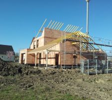 Vue sur le garage en trois pans de toiture, la maison en monoplan avec une extension à toiture plate.