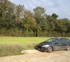 La voiture se trouve a l'entrée de notre terrain, nous avons un bout de terrain de 5m par 30m dans le champs. La maisson de trouvera derrière le bandeau d'arbre que nous allons abattre.