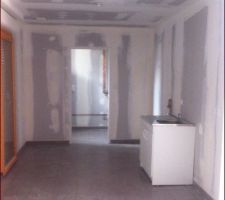 Cuisine et entrée cellier dont la porte a été enlevée temporairement.