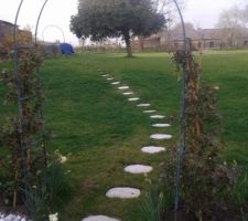 Pas japonais donnant acces au jardin entre 2 pierre de ronsard qui n'ont pas défleuri