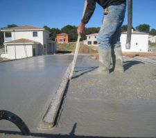 Le ma&ccedil;on dresse le b&eacute;ton sur le toit terrasse.