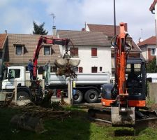 Tracto-pelle et camion "à pince" en action