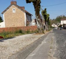 Pose d'une protection de trottoir en b&eacute;ton.