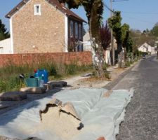 Pose d'une protection de trottoir en b&eacute;ton.