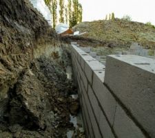 Les ouvriers travaillent même le samedi. Après avoir débuté leur journée à réparer les glissements de terrain, ils ont monté quelques rangées de parpaings.