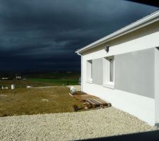 L'allée à côté de la terrasse sud toujours en chantier. Le terrassier n'avait pas compris qu'on voulait du gravier tout autour de la maison, il a oublié cette partie. En attendant de pouvoir faire les choses proprement, nous avons mis des cartons et palettes pour protéger les façades des intempéries sinon adieu le blanc au mur et bonjour les traces de boue !