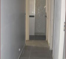 Le couloir du rdc menant &agrave; la chambre et salle d'eau -> reste &agrave; peindre en blanc le mur &agrave; droite et le dessus de la porte de la salle d'eau