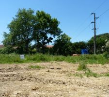 Sur cette photo, à gauche là ou sera ma maison (mon garage sera à peu près au niveau du panneau). Le grand box EDF sera la limite séparative avec mon voisin du lot 17. La ligne électrique juste au dessus sera enterrée et la bande de terre sera une servitude EDF appartenant à mon voisin du 17.